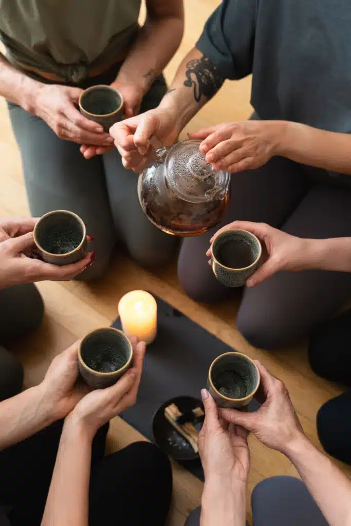 woman pouring tea to her friends during meeting