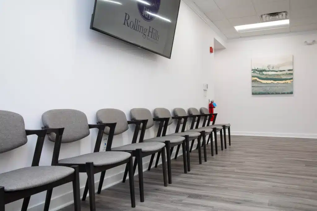 Group room at rolling hills recovery center with tv and logo mounted on the wall