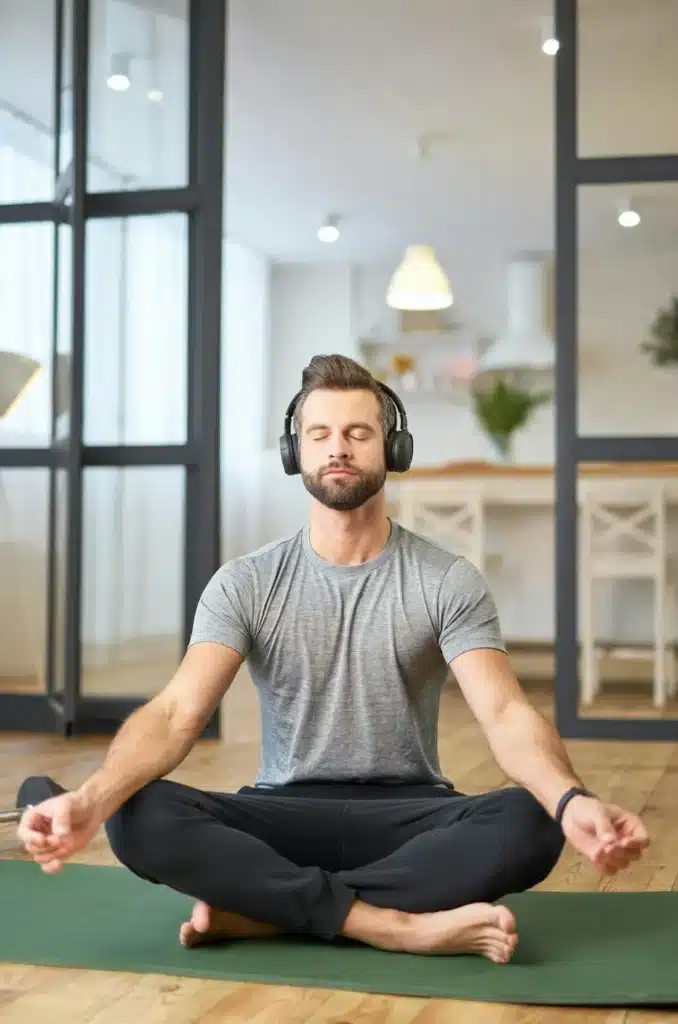 Bearded young man listening to music and meditating