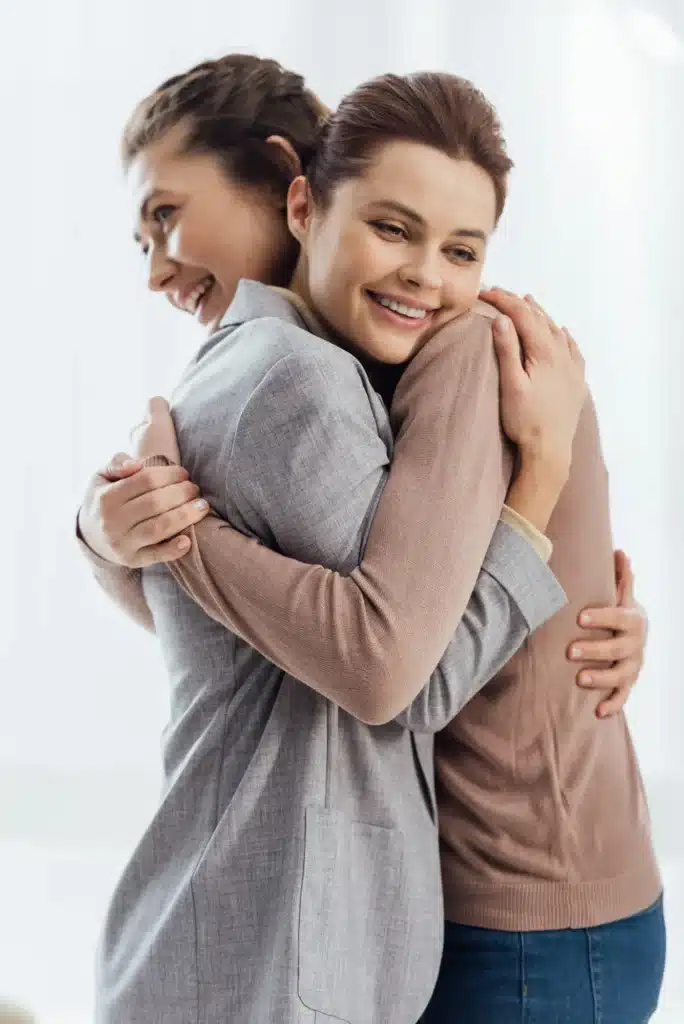 beautiful happy women embracing during therapy meeting