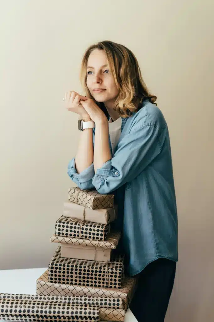 beautiful young woman packing a pile of gifts is bored