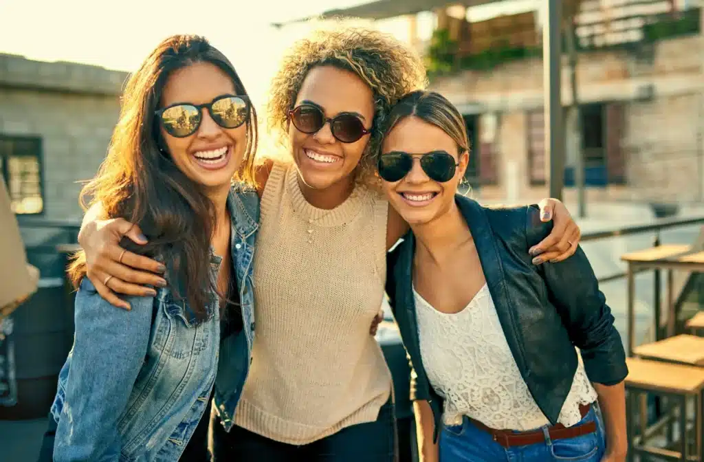 Cropped shot of three female best friends spending the day outside on a rooftop