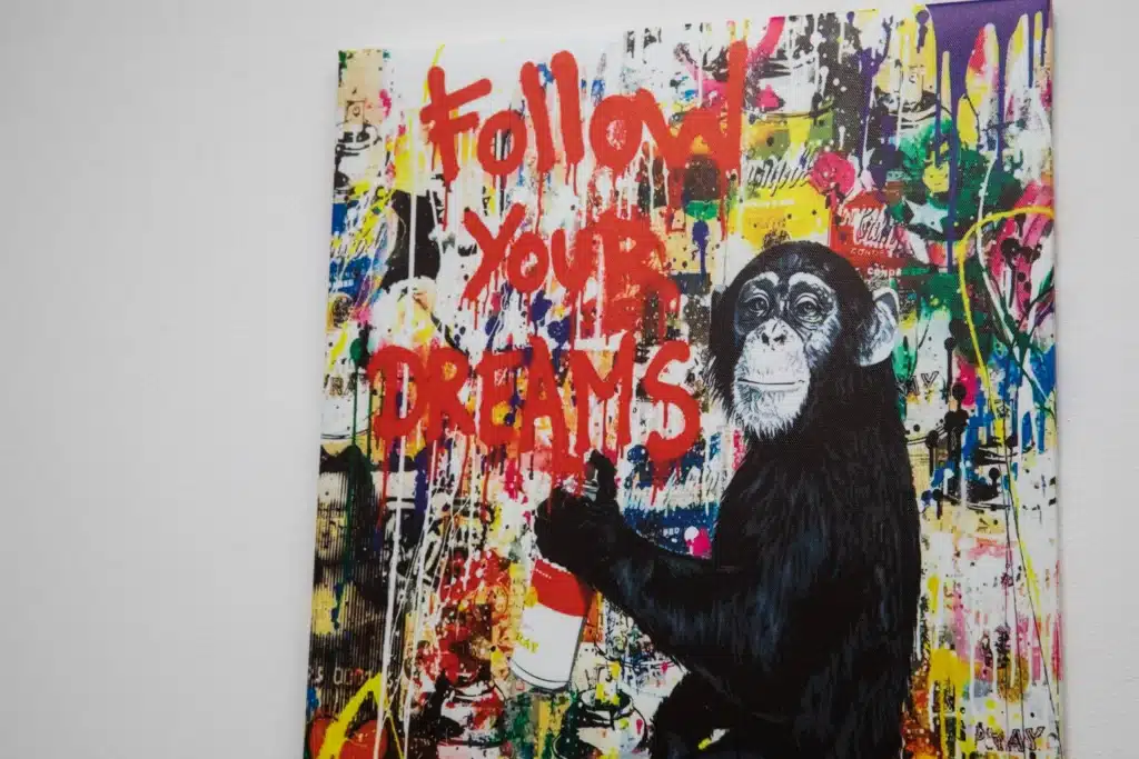 Painting on the wall of a monkey that says follow your dreams