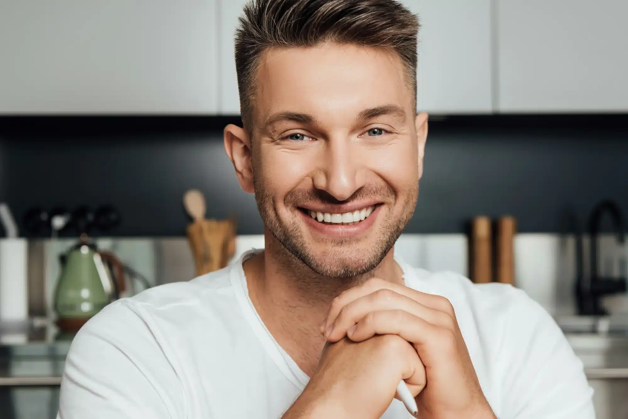 happy man with clenched hands smiling and looking at camera