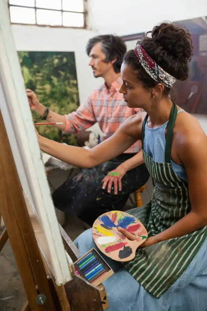 Man and woman painting on canvas