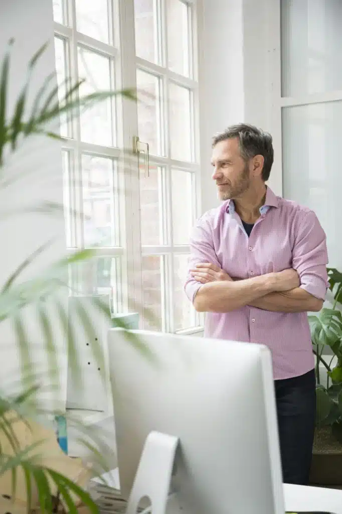 Man looking out of window in office