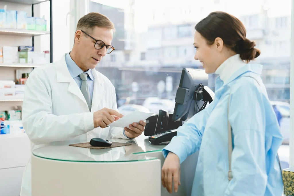 Pharmacist looking at medical prescription selling drugs medications medicines to customer