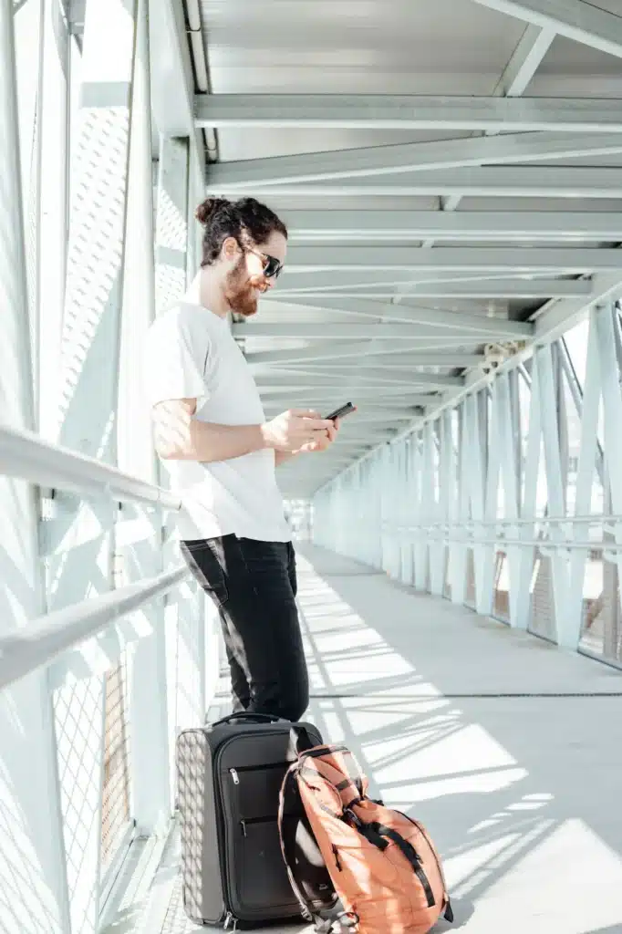 Portrait of a young man in casual clothes with a phone on the background of the modern airport