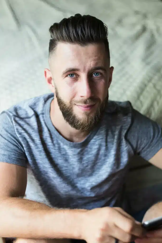 Portrait of handsome thinking young man looking at camera