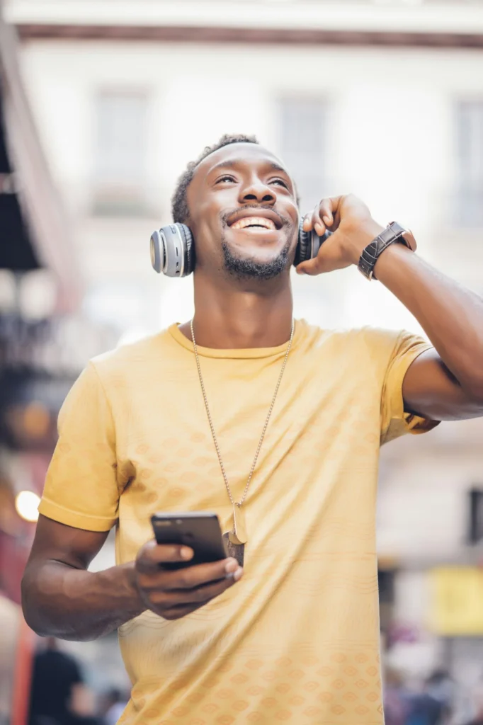 Portrait of happy man listening music with headphones and smartphone