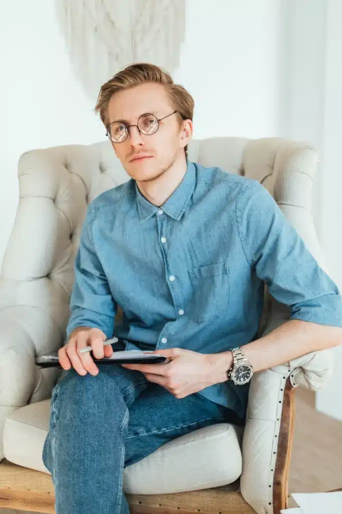 Portrait of serious caucasian man psychologist sitting in armchair at the workplace