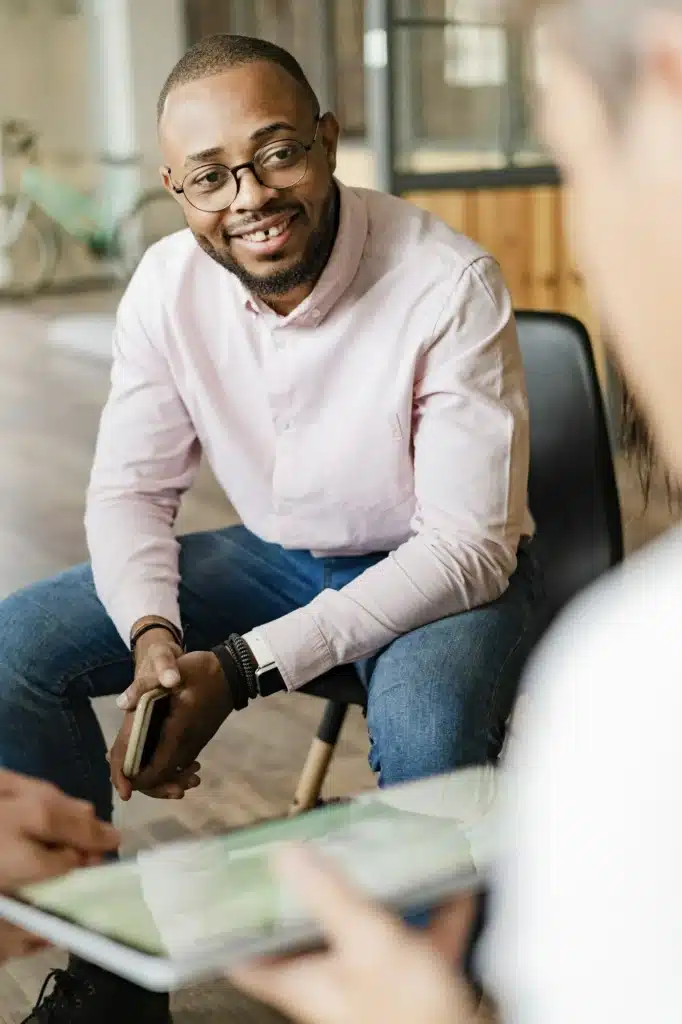 Portrait of smiling businessman listening to a presentation in loft office