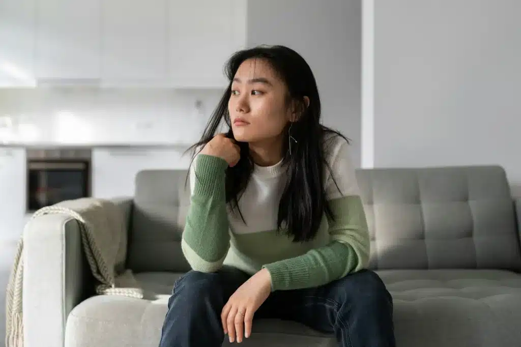 Sad lonely young Asian woman having depression symptoms worrying about money or family problems