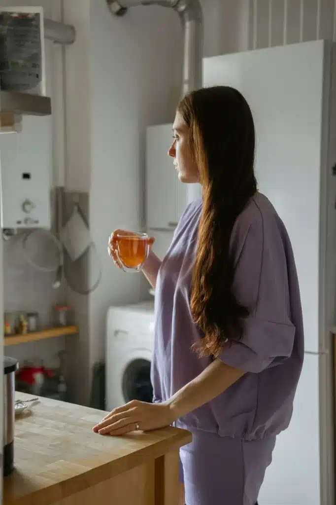 Woman Gazing Out Kitchen Window