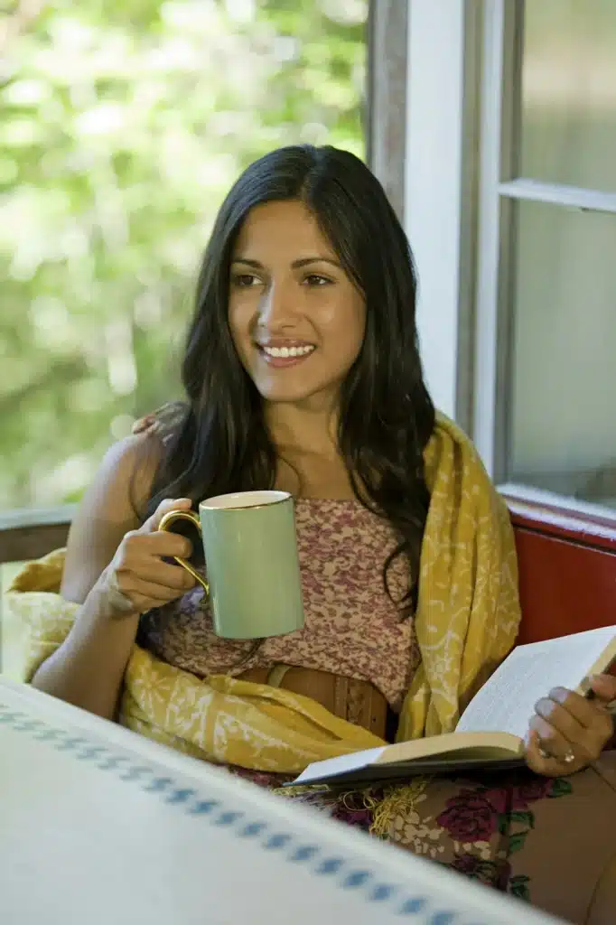 Woman relaxing with a drink and a book