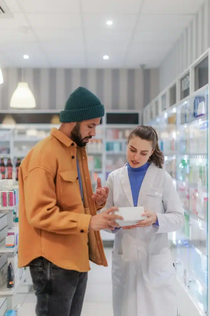 Young pharmacist helping customer to choos medication.