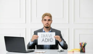 Young stressed worker in the office behind desk with computer having issues with adhd and addiction