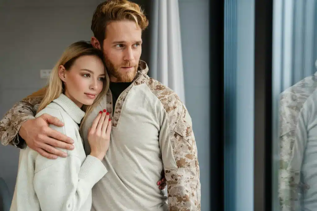 Beautiful young happy couple hugging and looking out window indoors