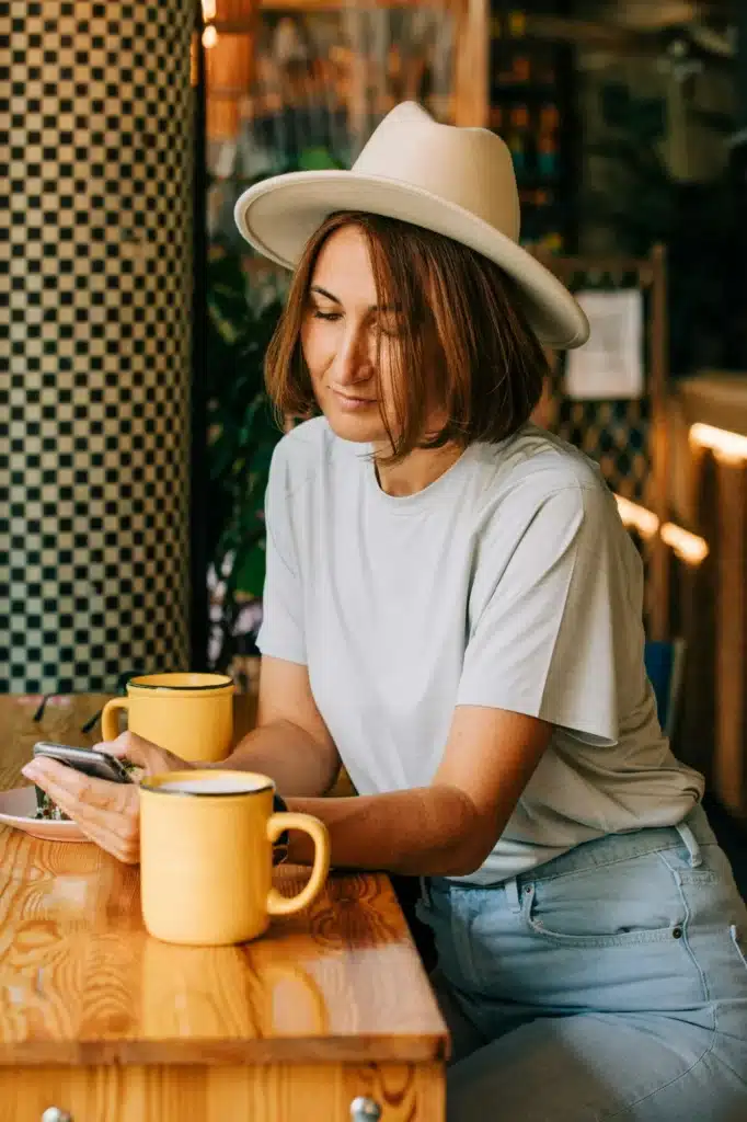 stylish fifty-year-old woman drinking coffee in a cafe