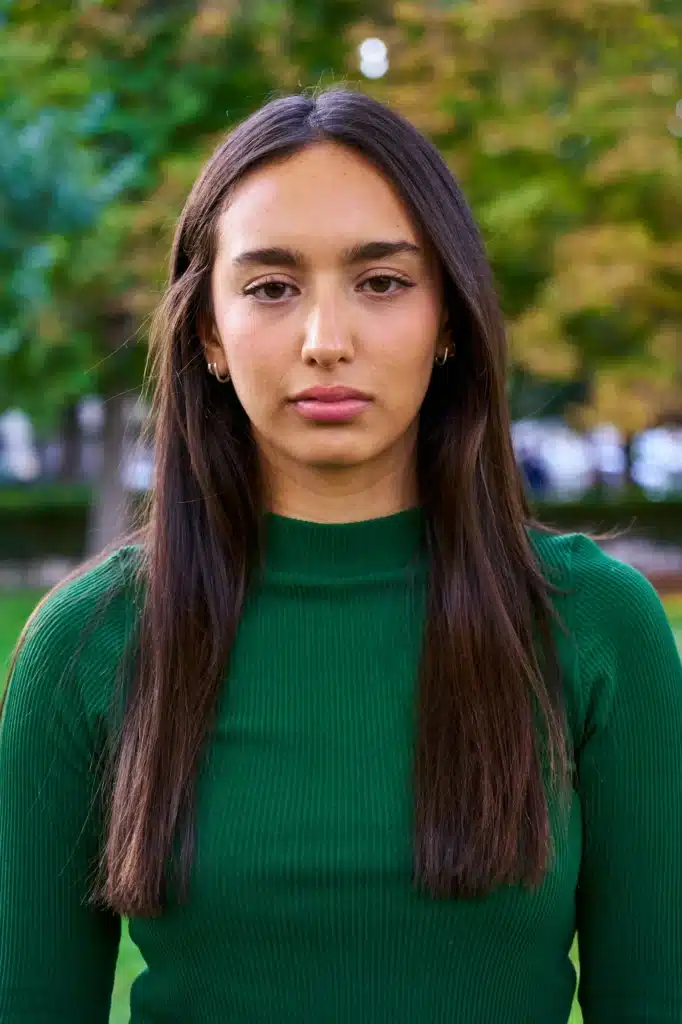 Portrait of a young brunette woman looking at camera with a serious face gesturing disappointment.